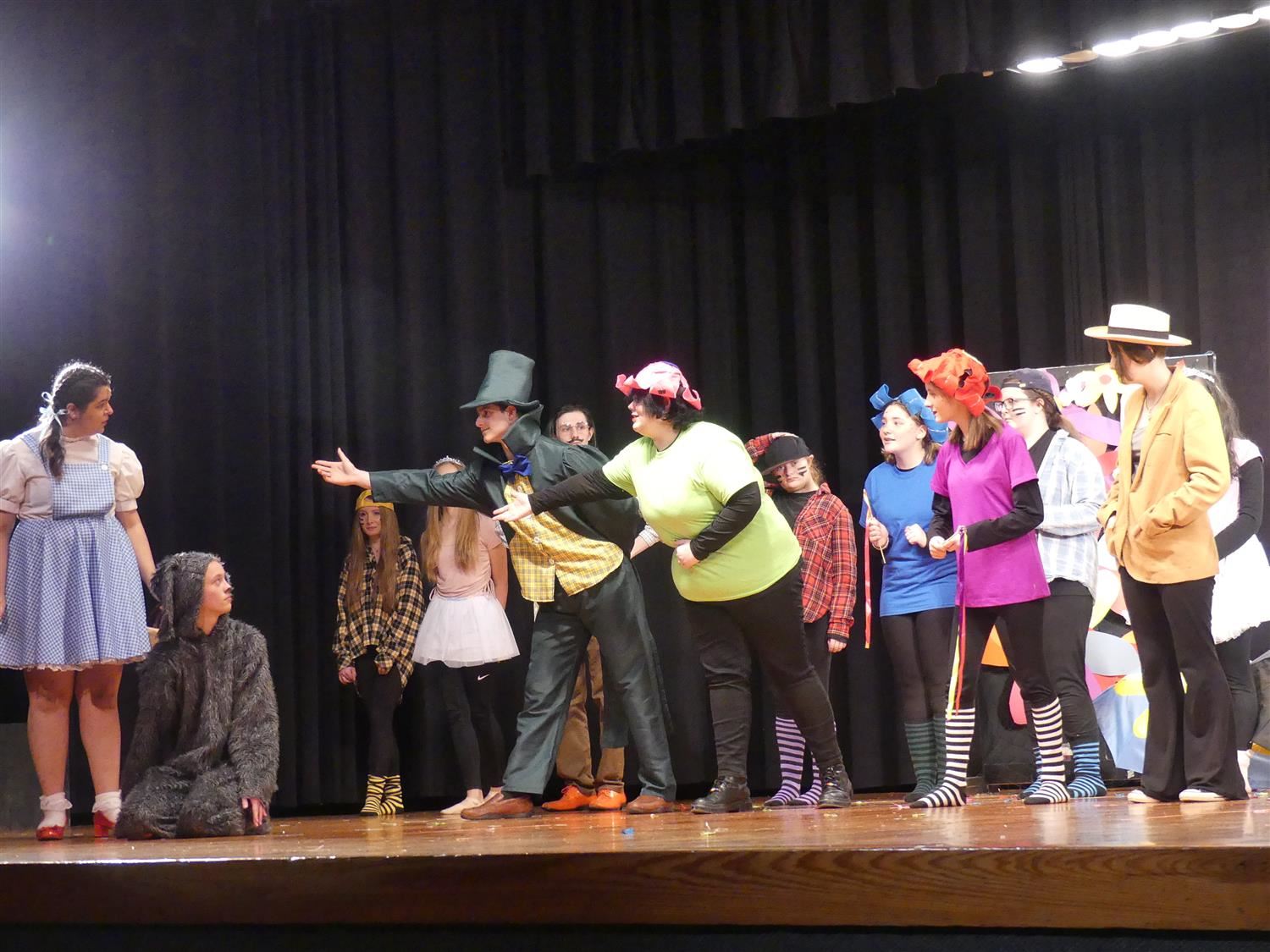 Students performing a scene from the Wizard of Oz on stage Students performing a scene from the Wizard of Oz on stage